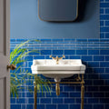 White ceramic pedestal sink with gold-toned brass fixtures and legs shown with windsor blue external corner trim