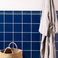 A woven beige basket with rounded handles against a vibrant blue Windsor blue field tile background