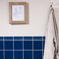 Blue square Windsor blue field tile with white grout forming a clean modern bathroom accent wall