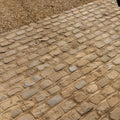 Weathered beige windsor sandstone cobble pavement with irregular reclaimed and sawn stones in a traditional pattern