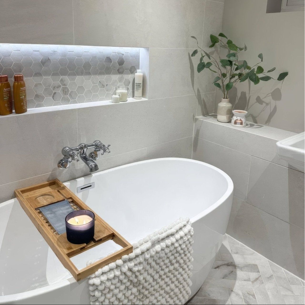 World Hexagon Tex White Mosaic white and grey hexagonal marble mosaic with a freestanding bathtub and candle