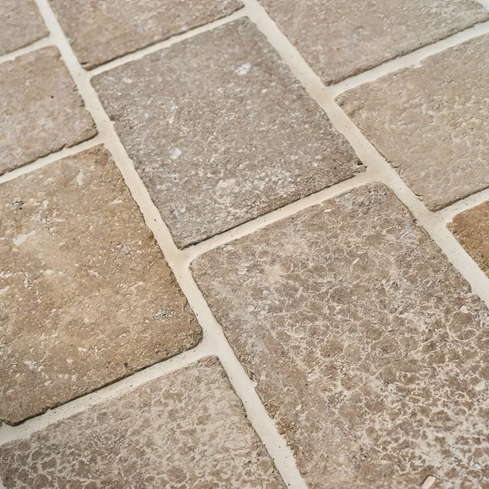 Beige wychwood limestone tumbled and etched cobble stone tiles with a textured rustic finish and natural tone variations