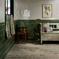 Green ceramic tile wall with white upper section and dark green lower half featuring wychwood limestone tumbled etched cobble