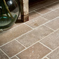 Beige rectangular wychwood limestone tumbled and etched cobble tiles with rustic texture and light gray grout lines
