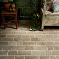 Terracotta-colored wychwood limestone tumbled and etched cobble floor tiles with rustic textured finish and grout lines