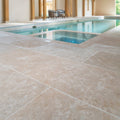 Beige wychwood limestone tumbled and etched finish stone tiles with textured natural finish in indoor pool area