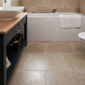 Beige wychwood limestone tumbled finish stone tiles 40 x 60cm covering bathroom floor and walls with earthy look