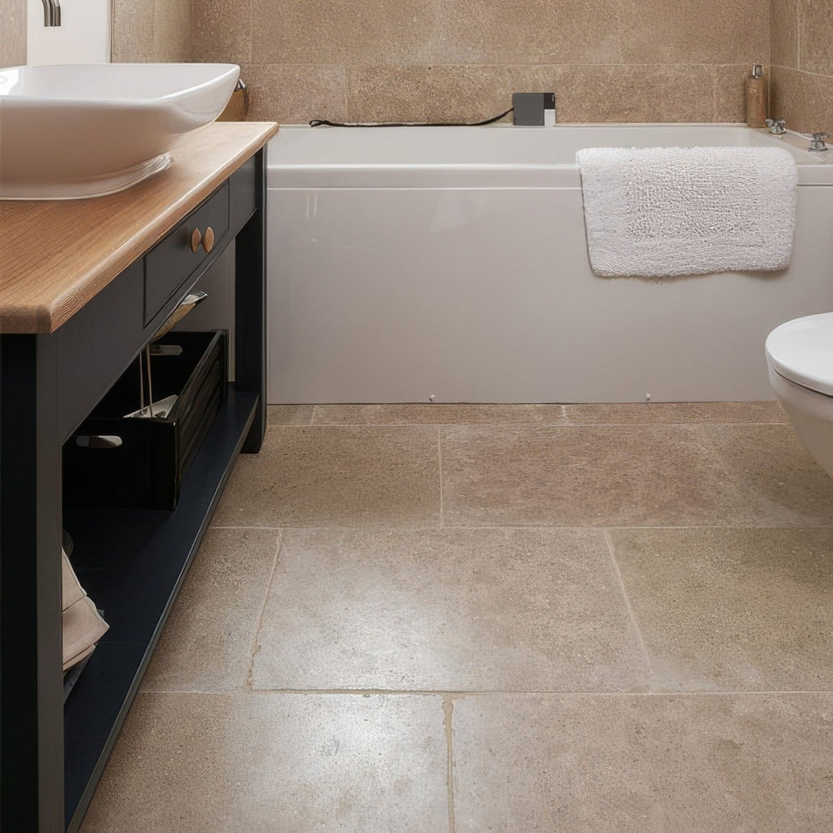 Beige wychwood limestone tumbled finish stone tiles 40 x 60cm covering bathroom floor and walls with earthy look