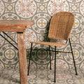 Woven wicker chair with black metal legs paired with zayda yellow multi matt vitrified ceramic tile 450x450mm