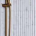 Zen Marble Reed Mosaic white marble reed mosaic with a gold showerhead and brass hose