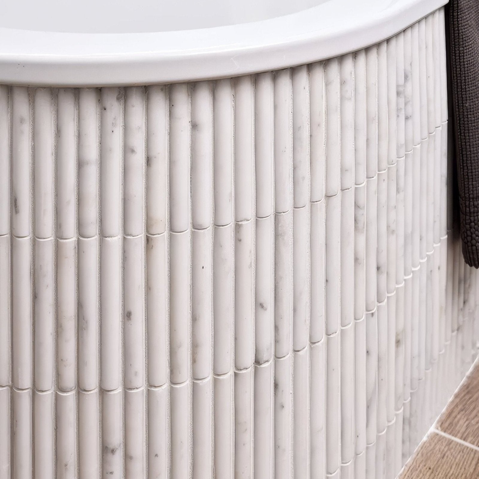 White marble bathtub with vertical ribbed texture from the zen marble reed mosaic collection