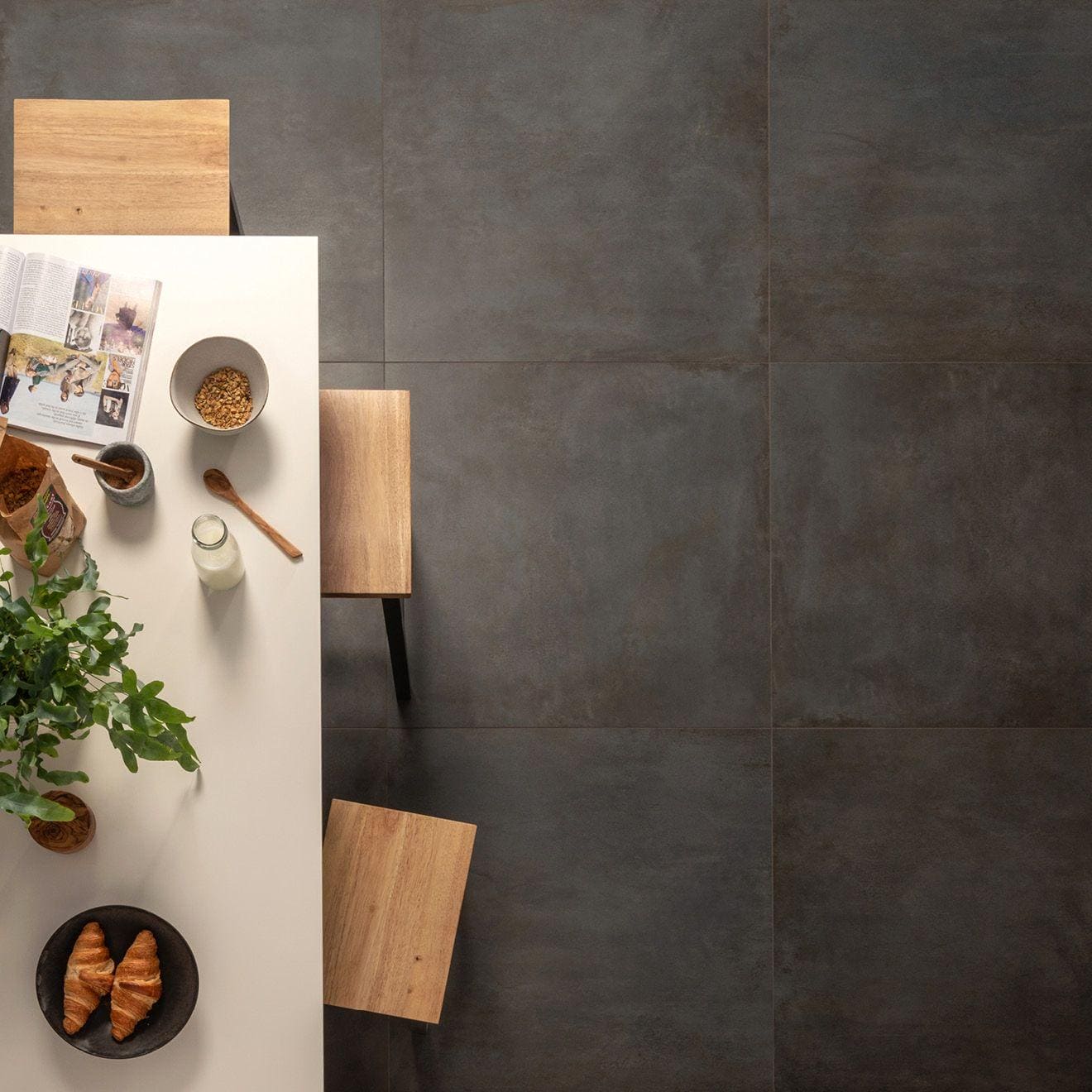 Dark gray matte-finish ceramic floor tiles with subtle texture and grout lines from alquimia dark blue natural collection