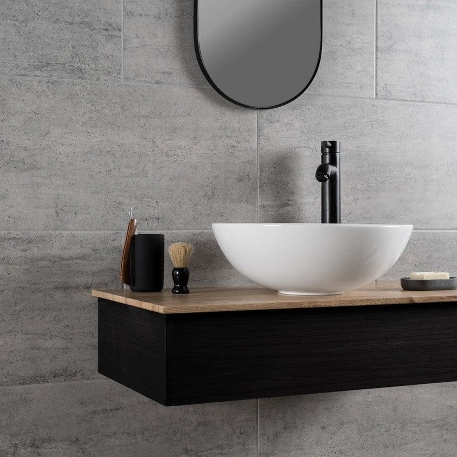 Atrium Marte Grafito Tiles grey concrete-effect tiles with a white bowl sink on a wooden countertop