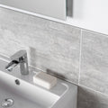 Atrium Marte Gris Tiles grey stone-effect tiles with a chrome tap and white sink