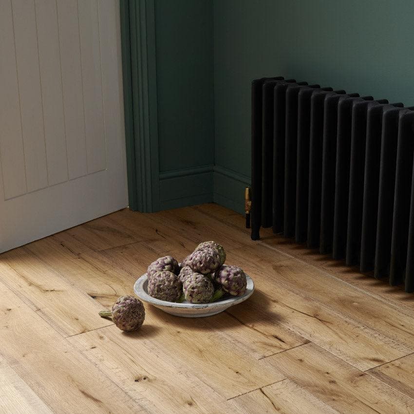 A white ceramic bowl with artichokes on a light wood floor showcasing Berkeley Cottage Oak flooring