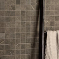 Burano Grey Recycled Glass Mosaic dark grey glass mosaic wall with a beige waffle towel on a black rack