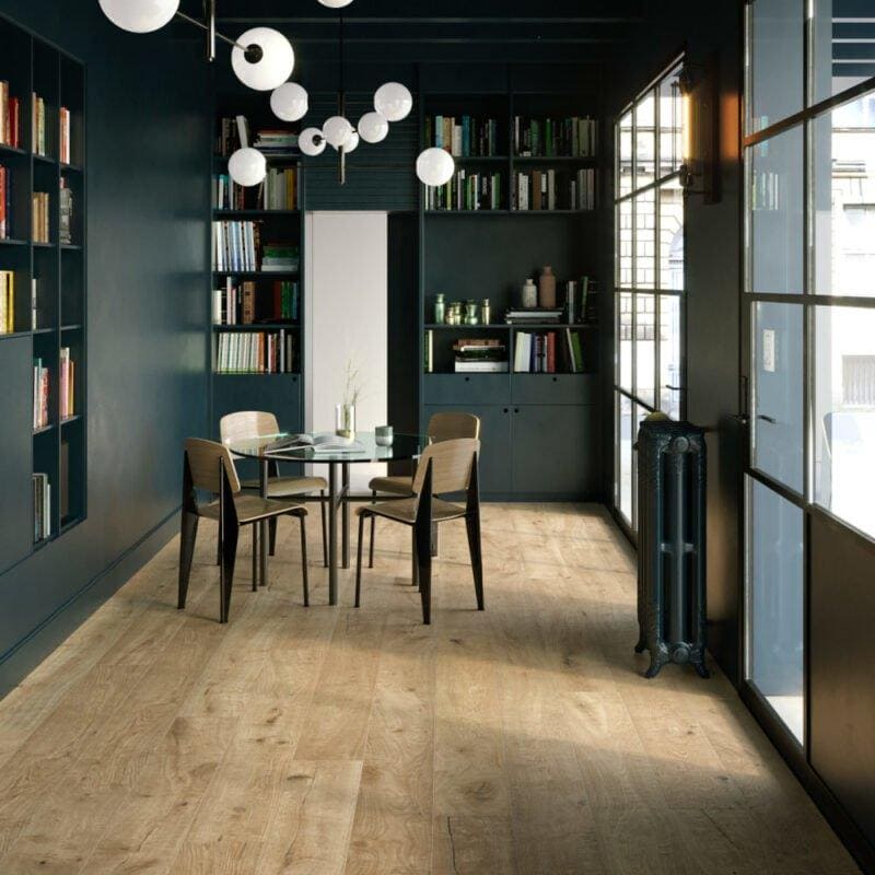 Dark teal glass-paneled bookshelves with a round glass table and wooden chairs in canaiolo natural style room