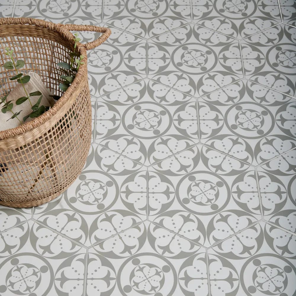 Hexagonal floor tiles with a repeating gray and white floral pattern from the carnaby hexagon grey collection