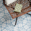 Carnaby Hexagon Sky blue and white floral hexagon tiles with a book on a wicker chair