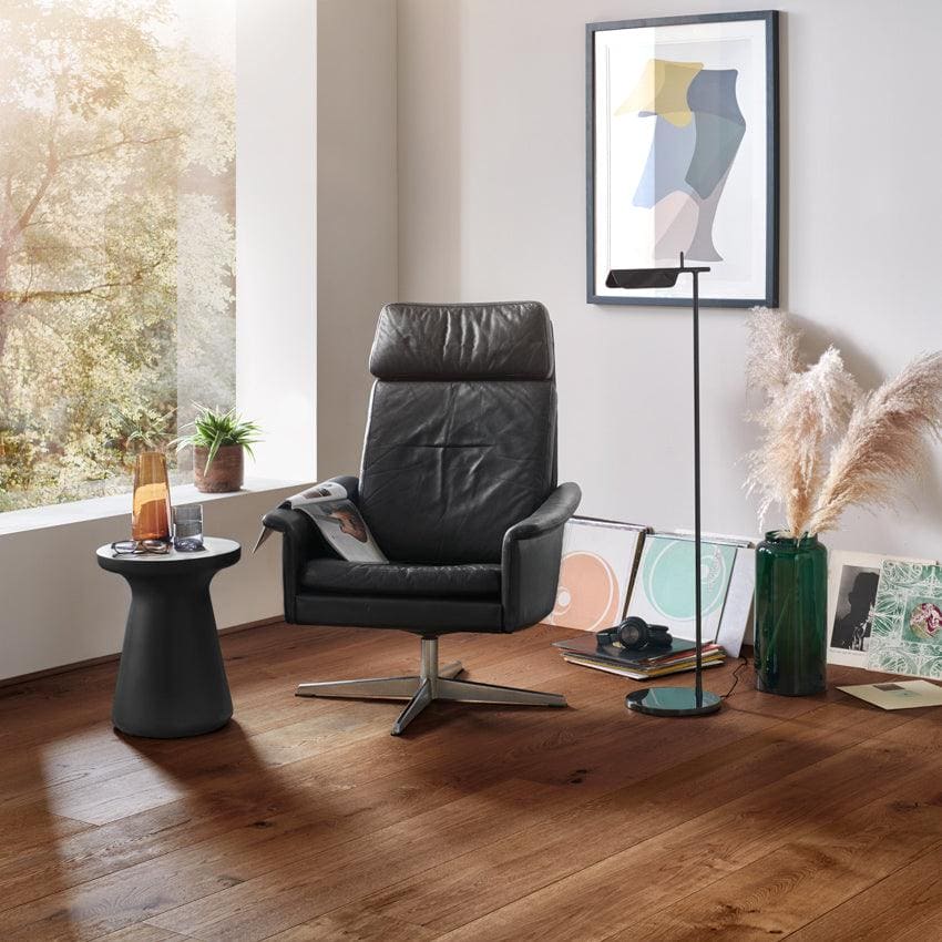 Black leather recliner chair with sleek modern design and chrome base in chepstow distressed charcoal oak finish