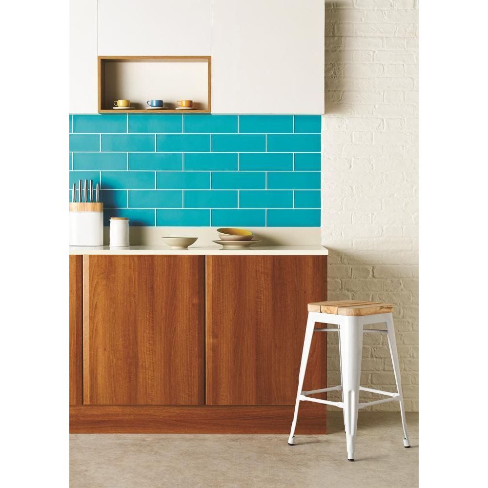 Colorado Clear Glass 300 x 100mm teal glass tiles with a white metal stool with a wooden seat