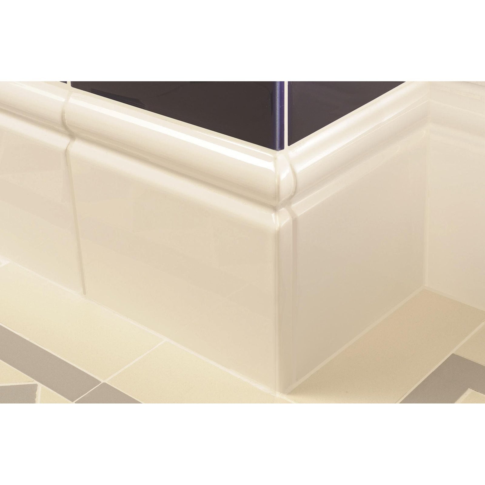 Cream-colored glossy ceramic bathtub base county white skirting right corner with smooth rounded profile and integrated molding