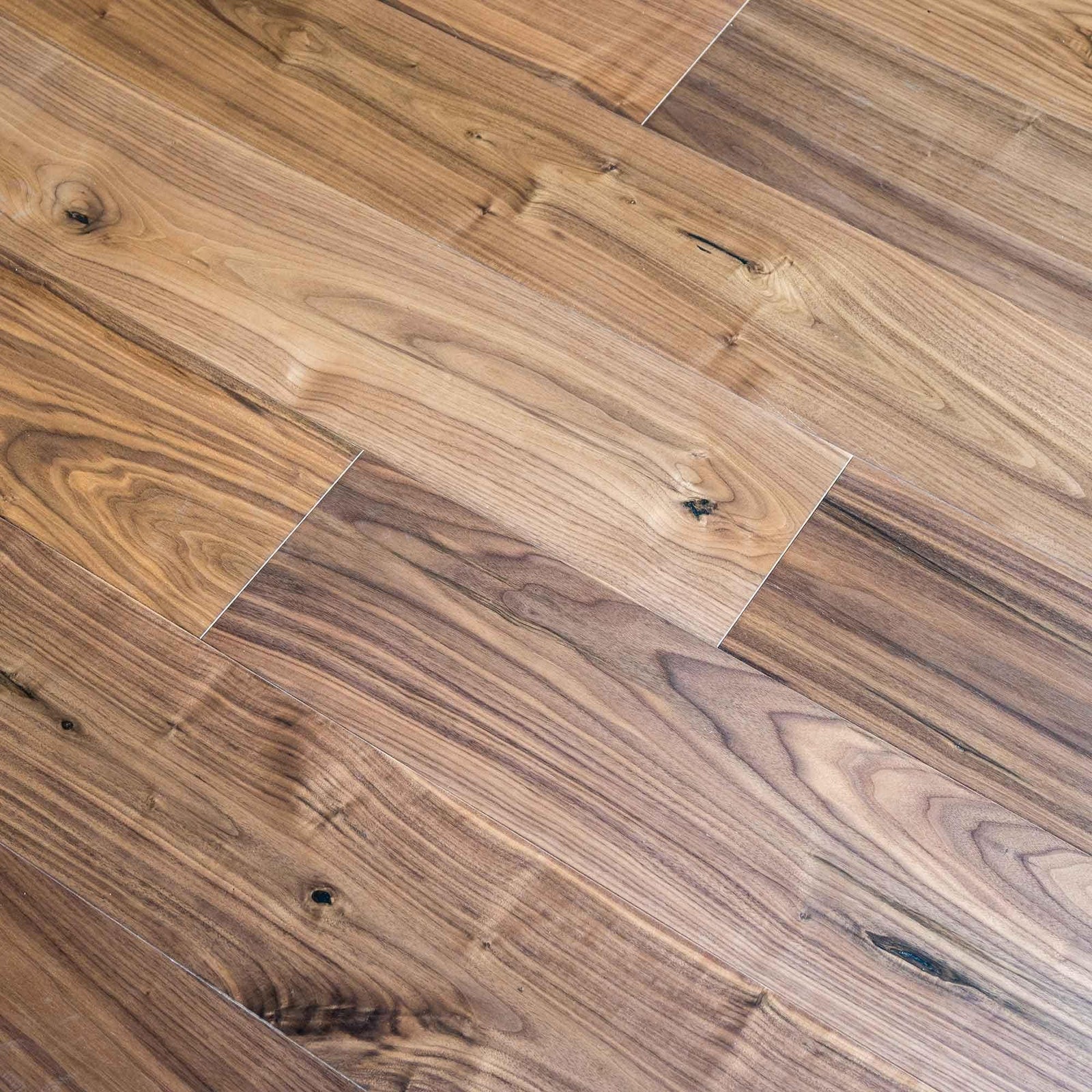 Warm-toned american black walnut hardwood floor planks with natural wood grain and visible knots