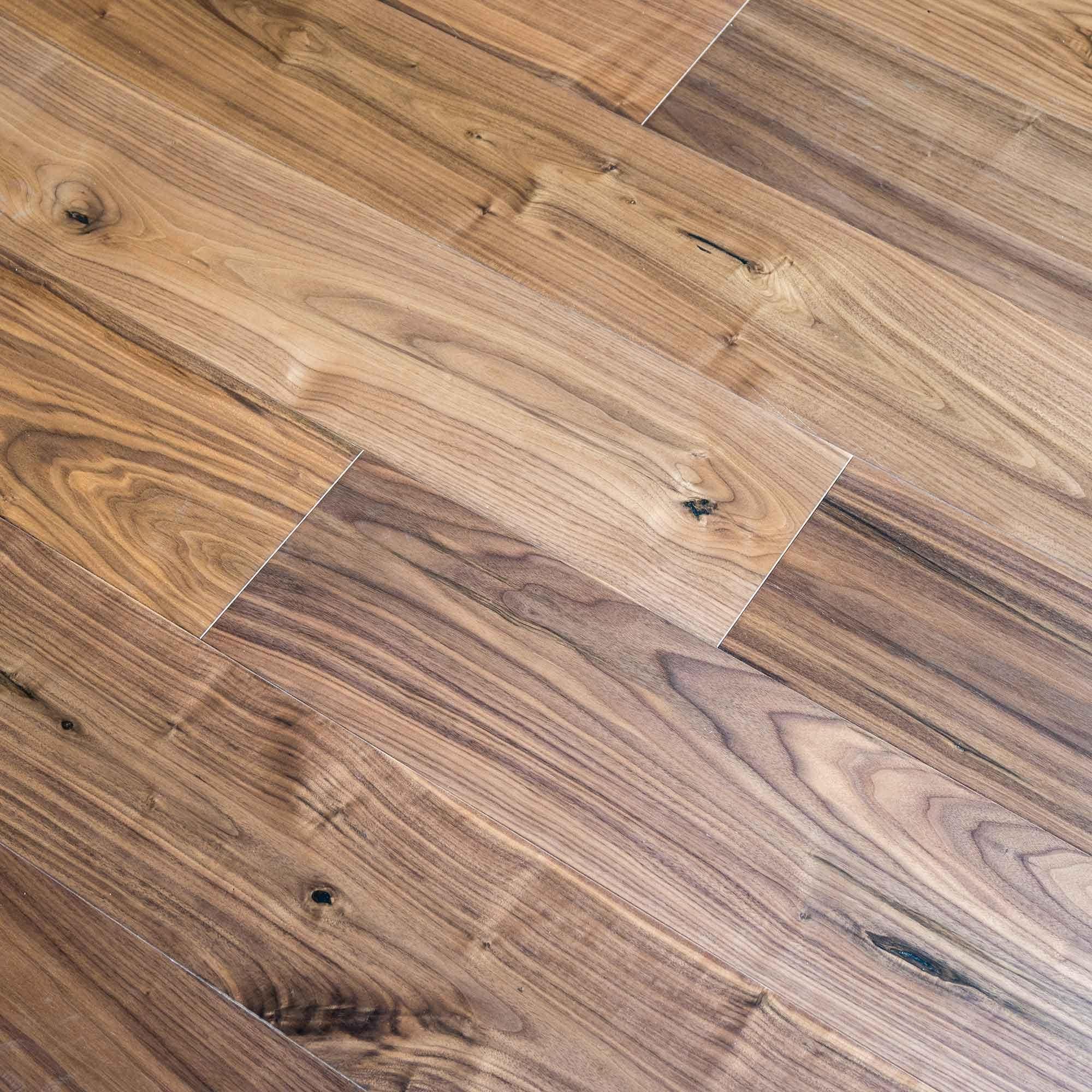 Warm-toned american black walnut hardwood floor planks with natural wood grain and visible knots