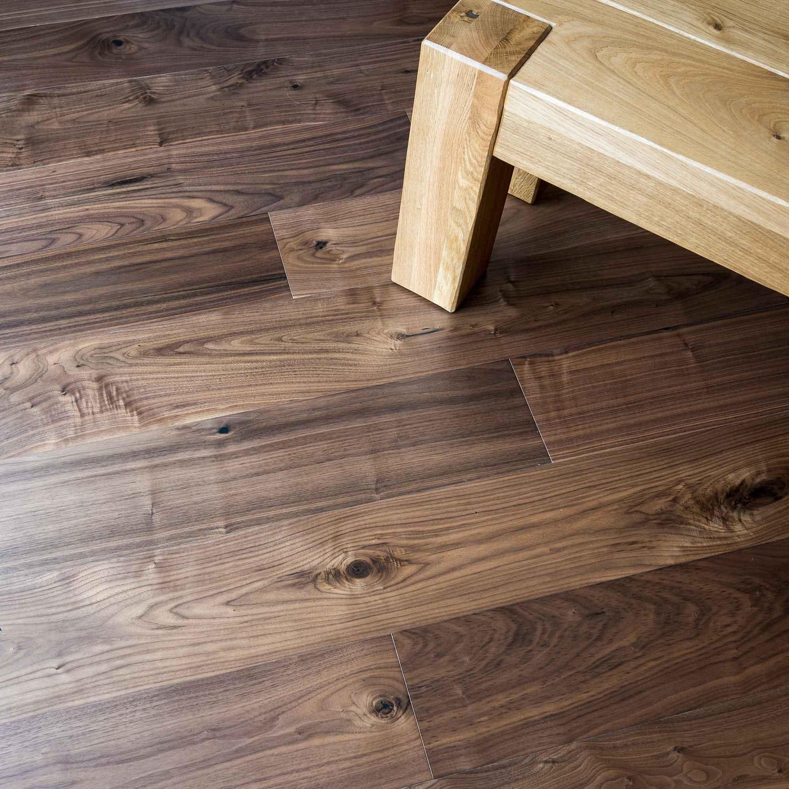 Dark brown american black walnut hardwood floor planks with natural wood grain and visible knots dc205