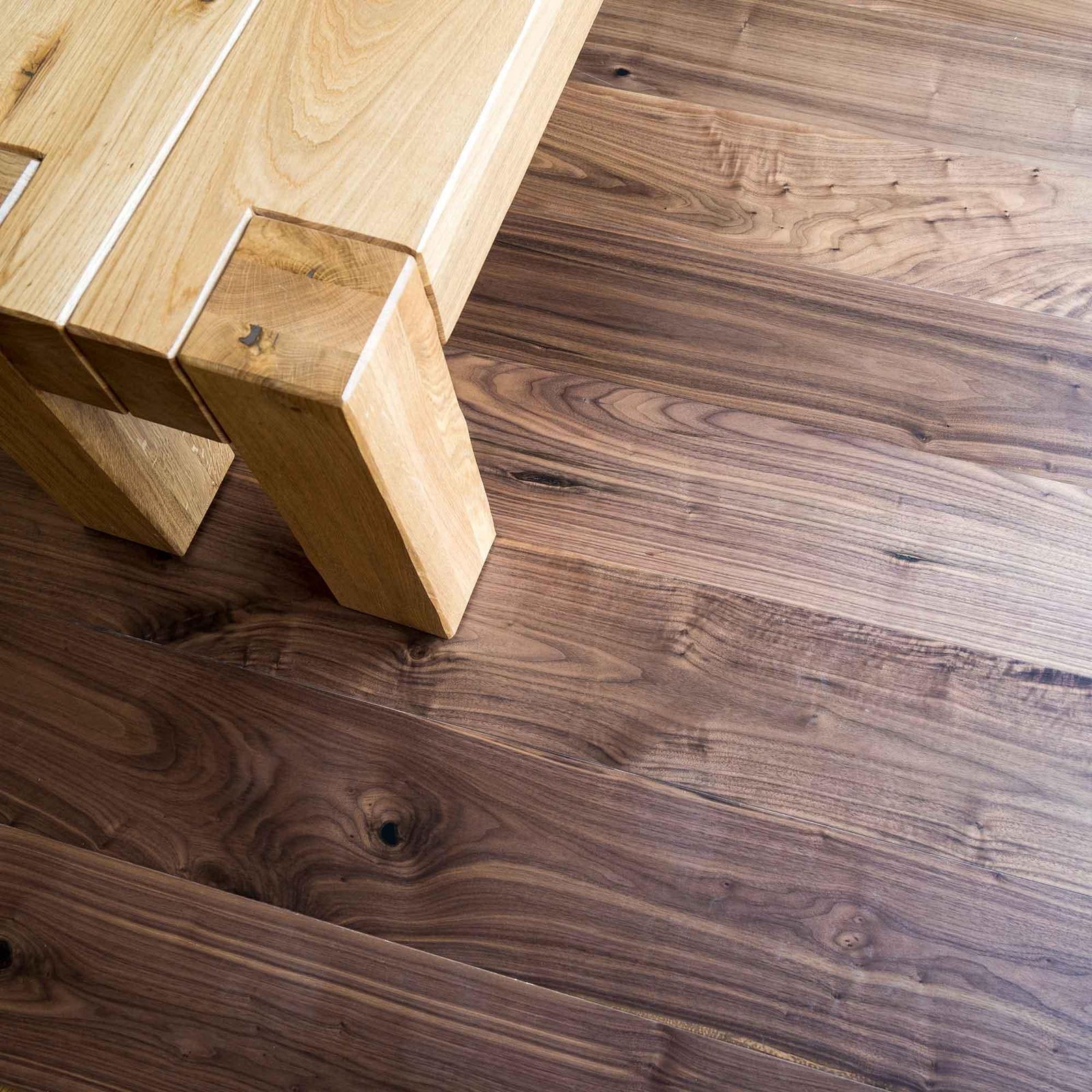 DC205 American Black Walnut dark walnut engineered wood flooring with an oak table leg