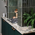 Dark green porcelain ceramic tiles with white grout forming a modern kitchen backsplash from foundry smeraldo