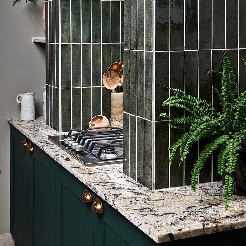 Dark green porcelain ceramic tiles with white grout forming a modern kitchen backsplash from foundry smeraldo