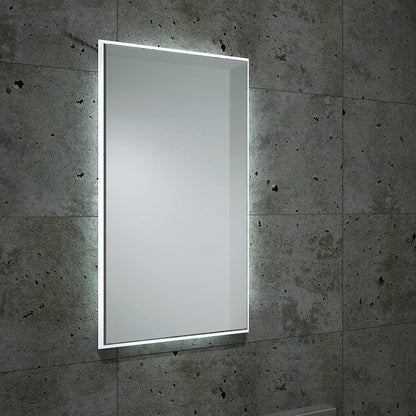 Rectangular frameless fractal mirror 120 with integrated led lighting mounted on a textured concrete wall