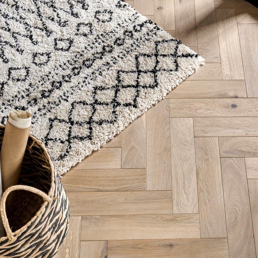 Goodrich Feather Oak light oak wood flooring with a cream geometric-patterned rug