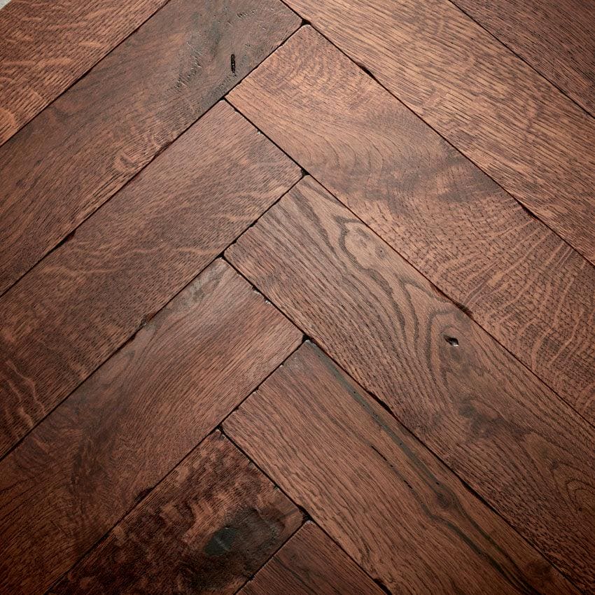 Goodrich foundry oak hardwood floor planks in rich dark brown arranged in a herringbone pattern