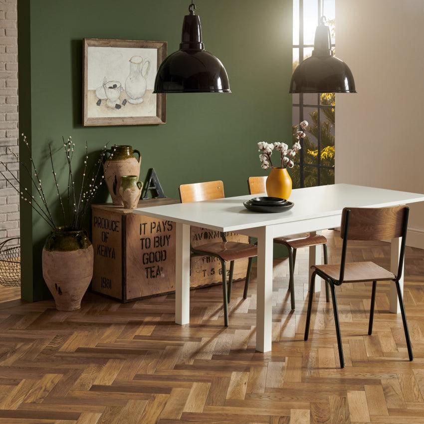 White rectangular dining table with sleek white legs and minimalist design surrounded by smoked oak wooden chairs