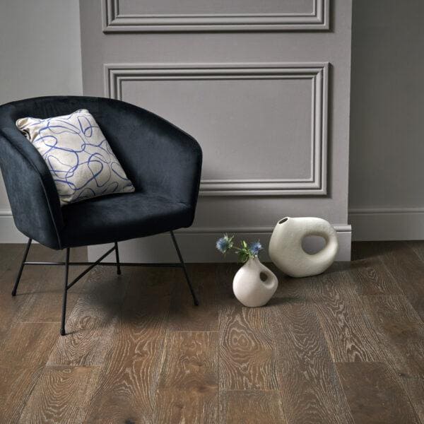 Dark navy velvet armchair with a white pillow featuring blue abstract lines in harlech espresso oak style