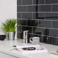 Hermes Metallica dark grey metallic glass tiles with a stainless steel moka pot