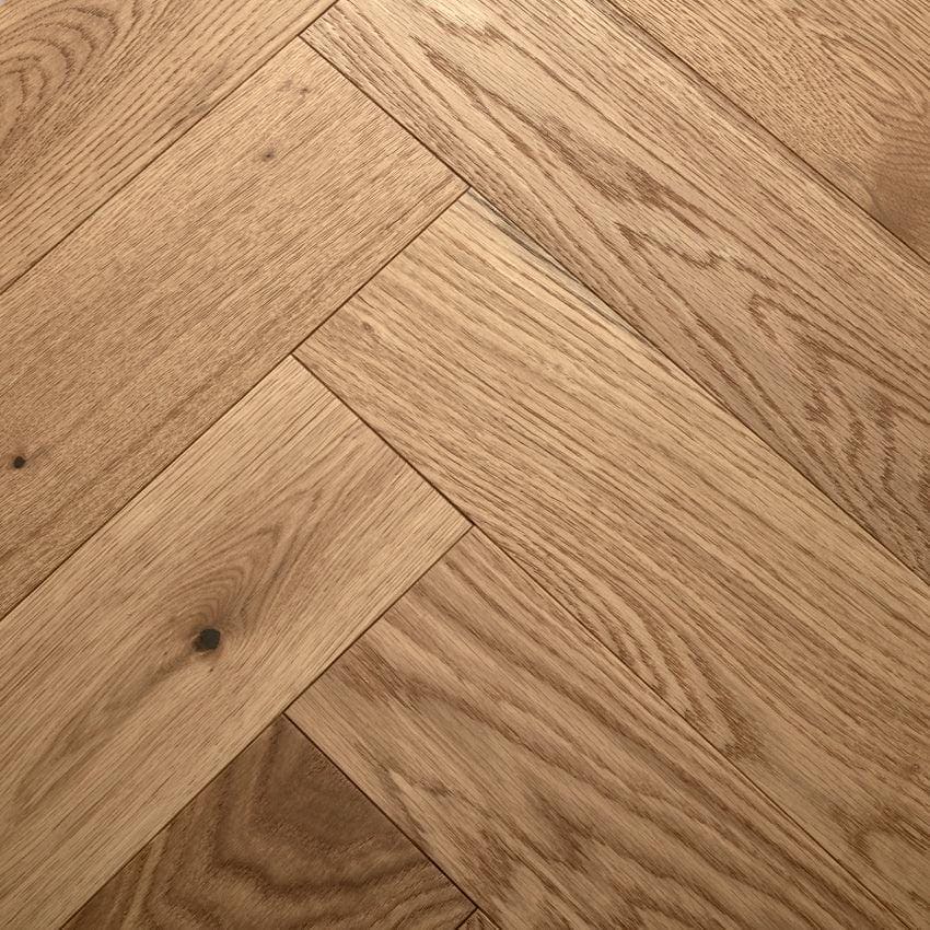 Highclere natural oak light brown hardwood floor planks arranged in a herringbone pattern
