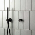 Hydrus Constellation Glass 300 x 100mm silver glass tiles with a black shower fixture