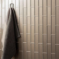Hypnos Brickbond Mosaic beige glass brick mosaic with a dark grey towel on a hook