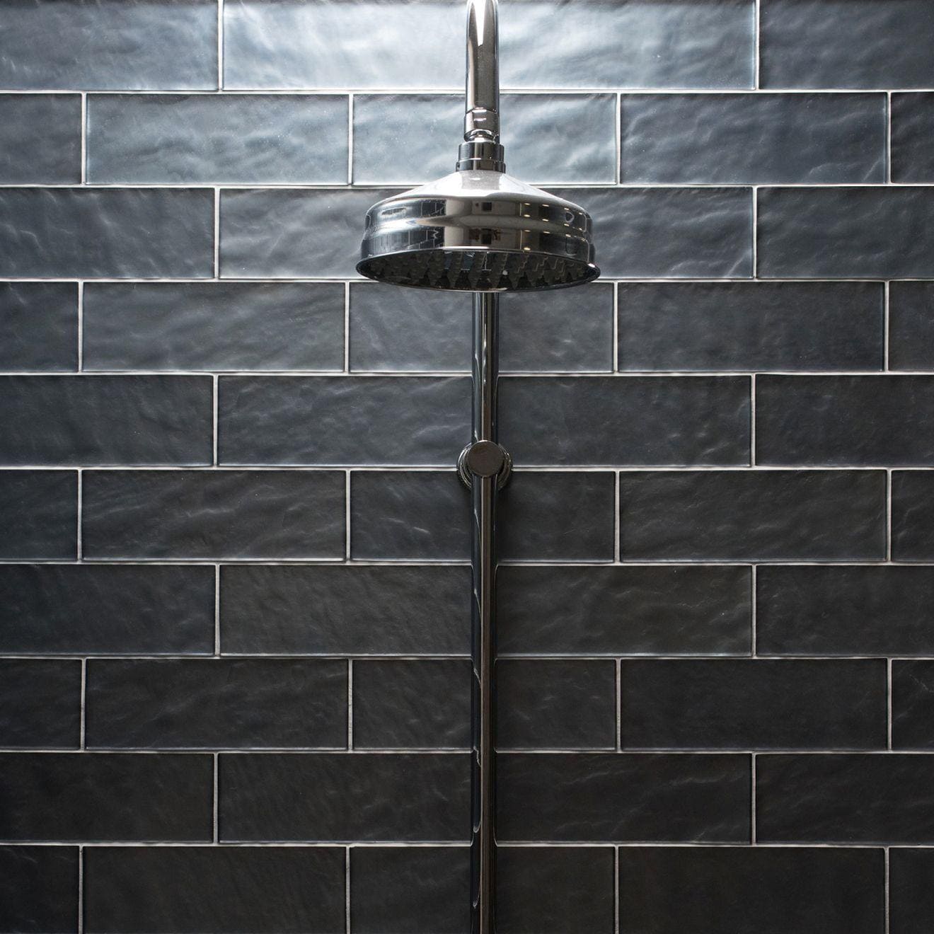 Janus Eclipse glazed metro tiles with a chrome showerhead