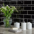 Jet Black Rectangle wall tiling with a ribbed glass vase of white flowers set against it