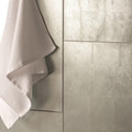Karnak Decorative Glass silver metallic glass tiles with a white waffle towel