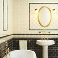 Gold-framed oval mirror above sink with laudatory wreath charcoal grey tile set on county white wall
