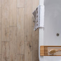 Lignum Cream Natural Rectified Glazed Porcelain cream wood-effect porcelain tiles with a striped towel on a bathtub