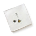 White linen napkin with printed bumblebee and silver spoon design from menagerie ceramic by michael angove