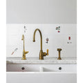 Brass kitchen faucet with curved spout and golden handle from Menagerie Ceramic by Michael Angove