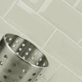 A metallic metro light grey gloss strainer with a brushed finish and evenly spaced circular perforated holes