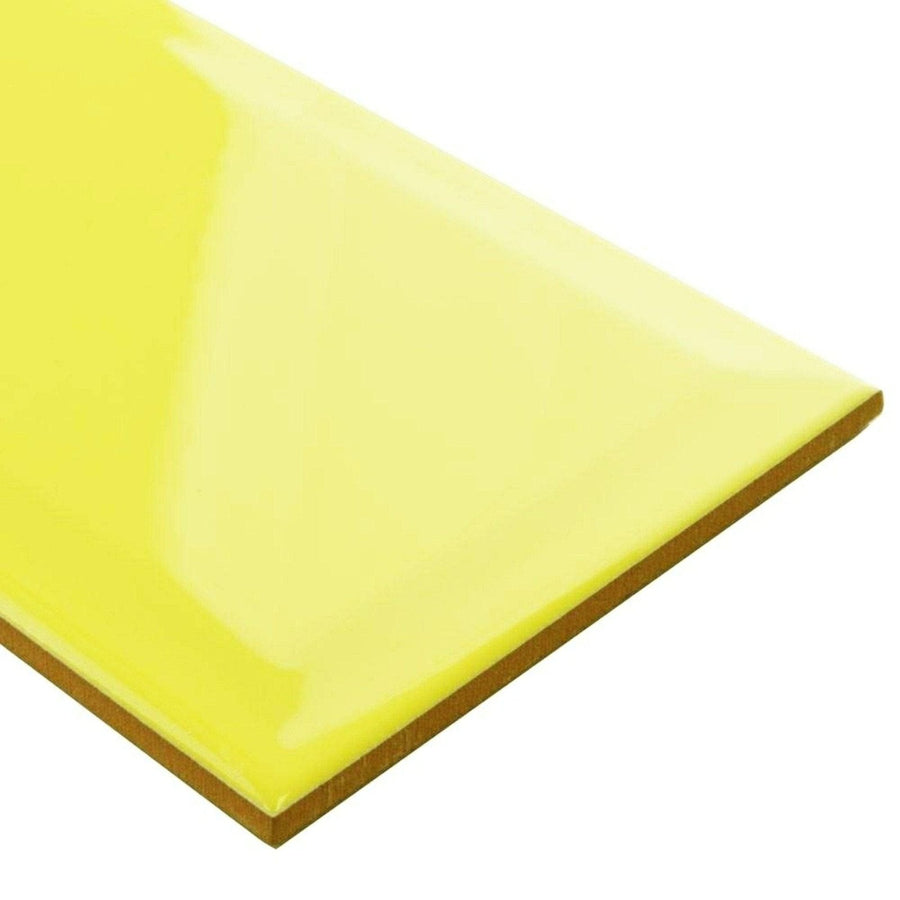 Bright yellow glossy ceramic tile metro limon gloss with smooth reflective surface and visible brown edges